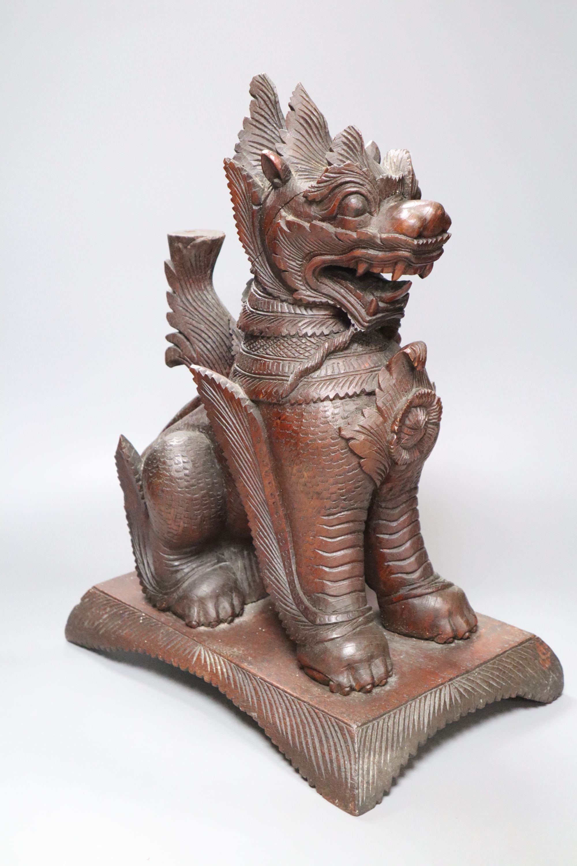 An Indonesian large carved wood model of a seated kylin, on plinth base and two Chinese rootwood carvings of elders, H approx 44cm (kyl